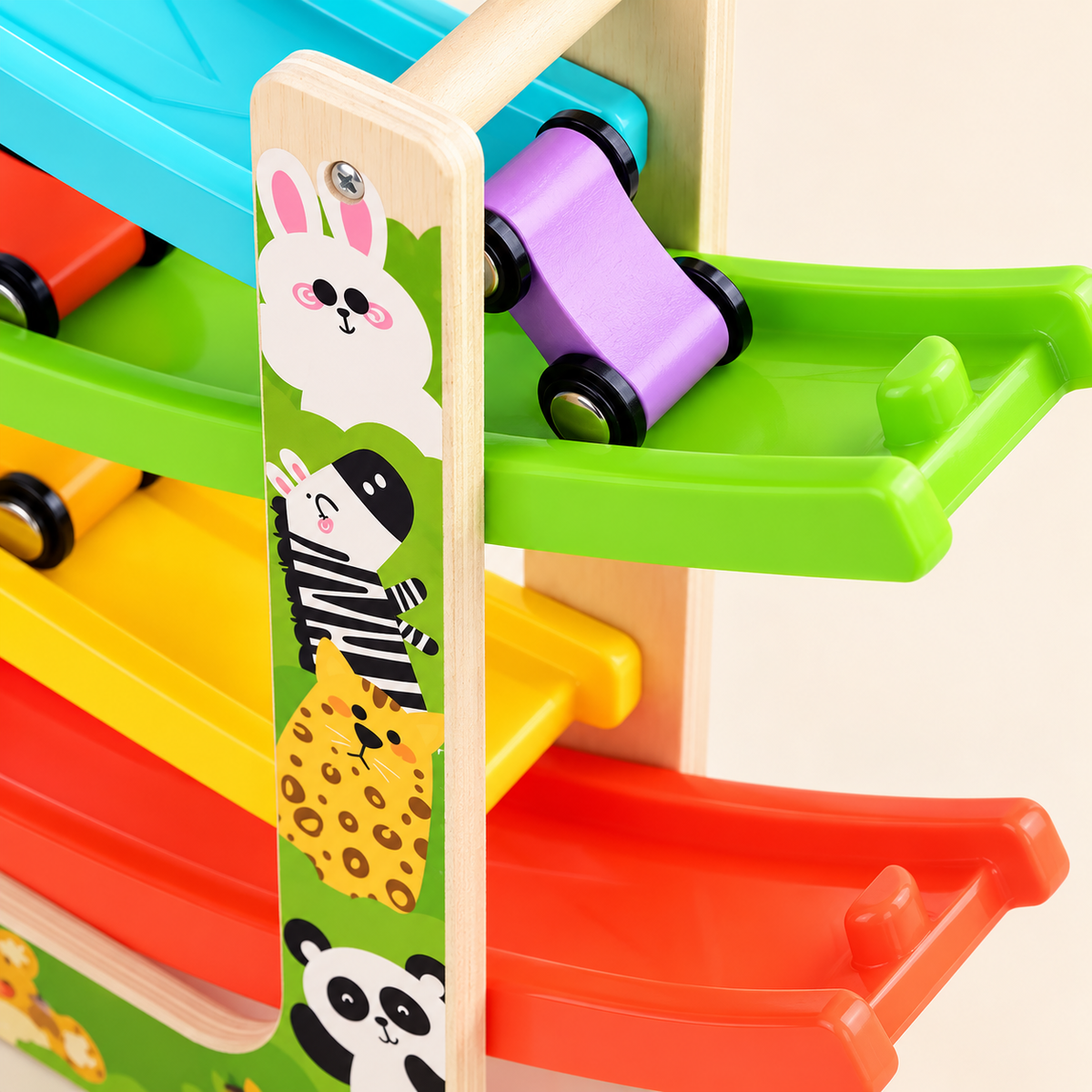 Detail van de houten racebaan met dierenillustraties en een paars autootje op de groene baan