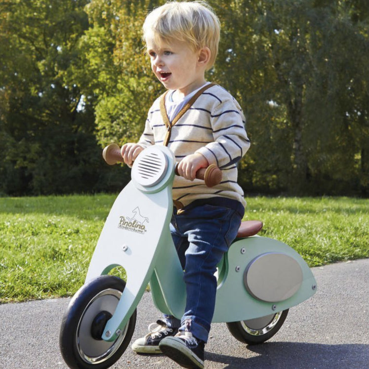 Loopfiets scooter vespa mint met een peuter erop